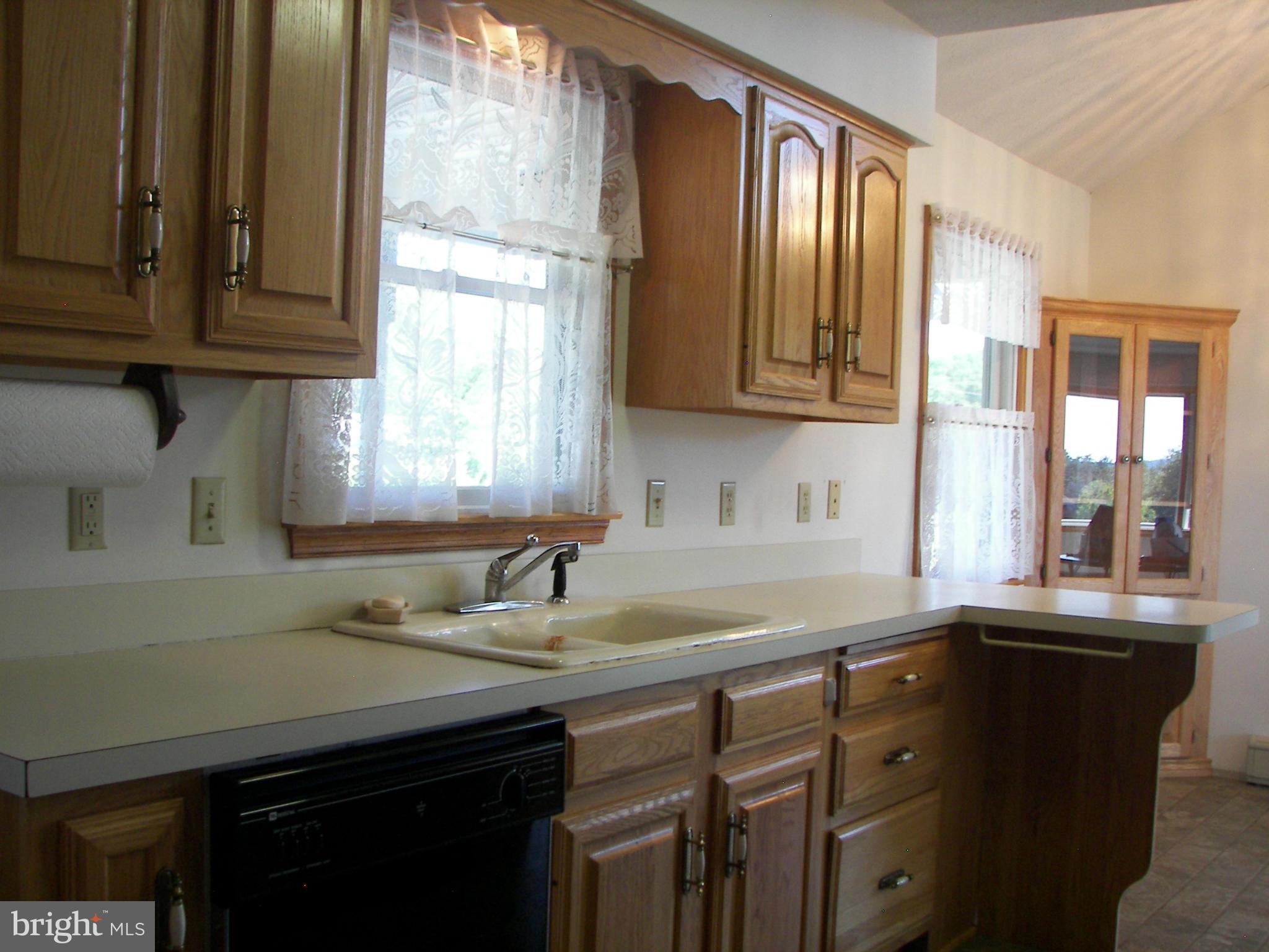 2483 Potomac Road Berkeley Springs, WV 25411 - Photo 14 of 30 a kitchen with granite countertop a sink a window and cabinets