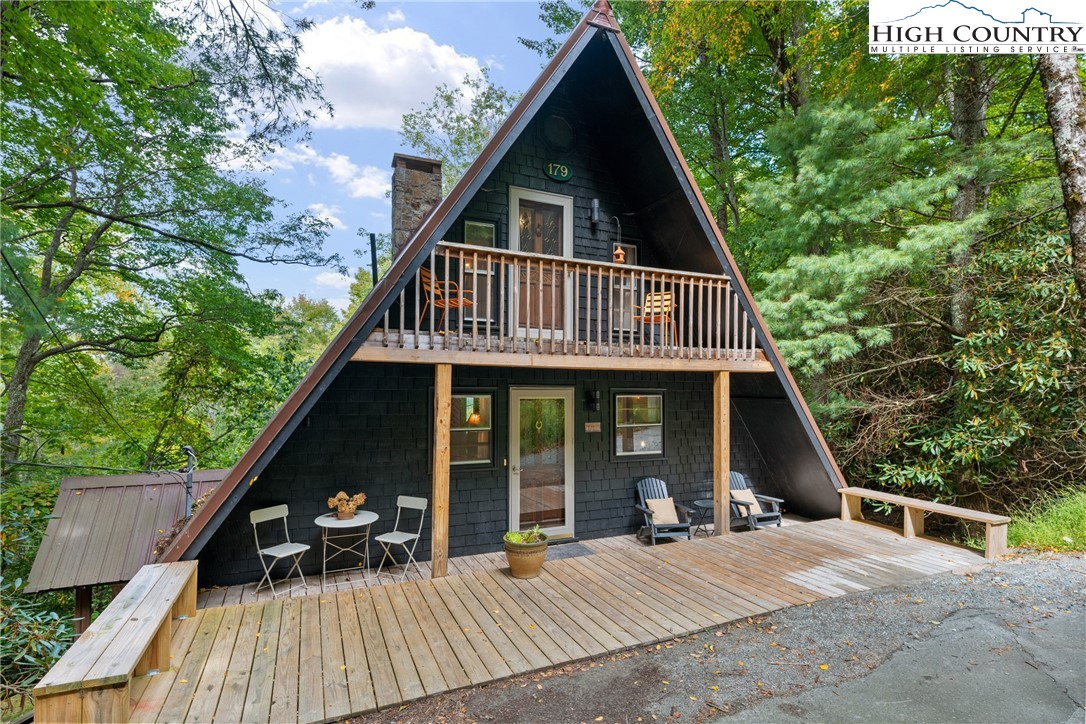 a view of a house with a yard and wooden deck