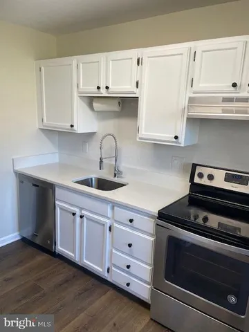 a kitchen with cabinets appliances and a sink