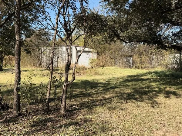 a view of a yard with wooden fence