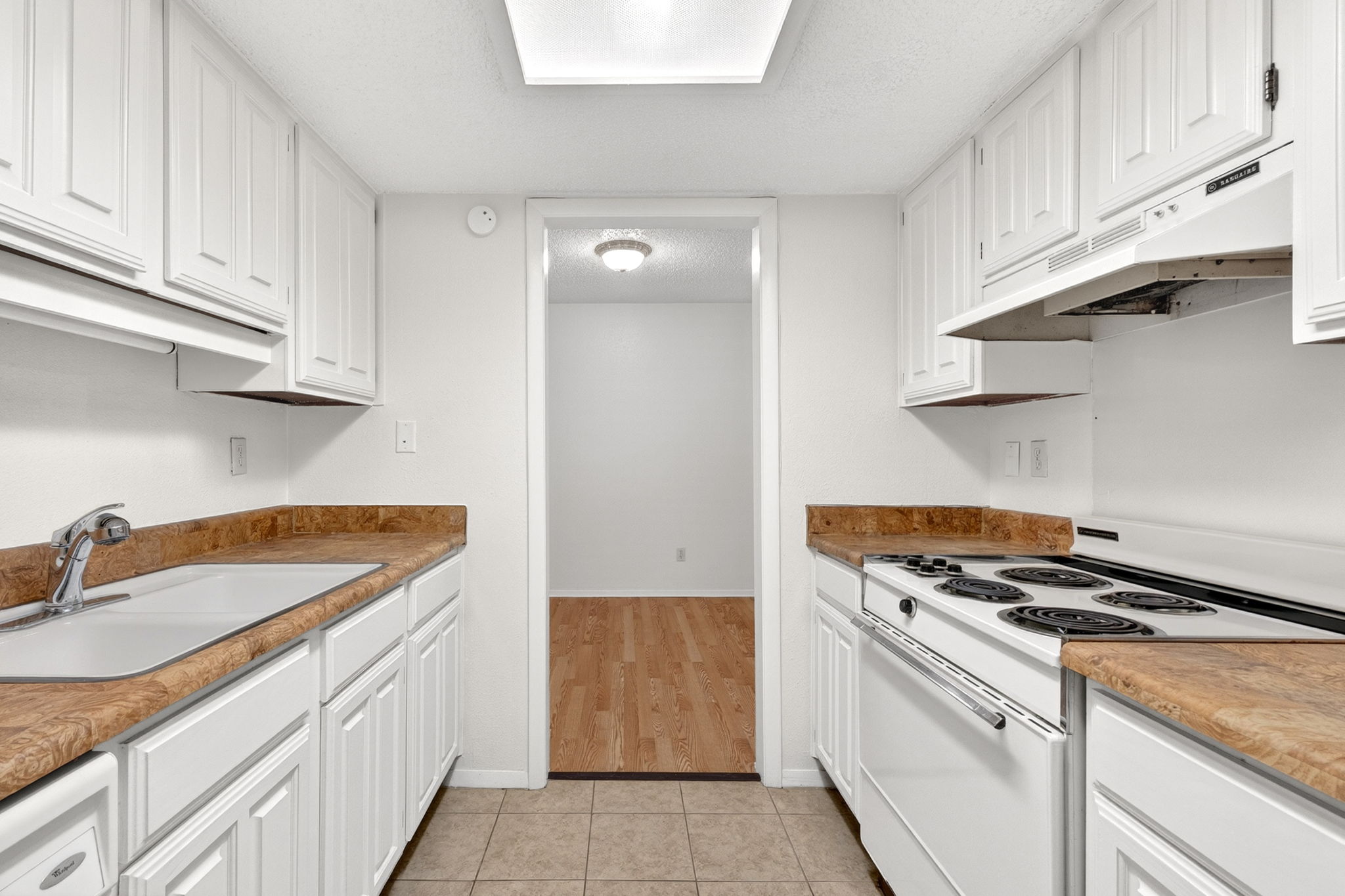 8210 Bent Tree Road, Unit 256 Austin, TX 78759 - Photo 11 of 29 a kitchen with granite countertop a sink stove and cabinets