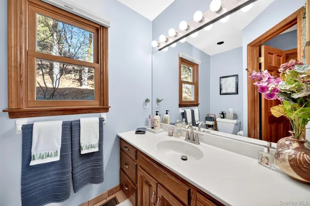 a bathroom with a sink mirror and window