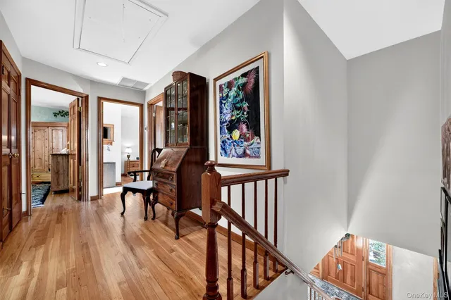 a view of a hallway with wooden floor and furniture
