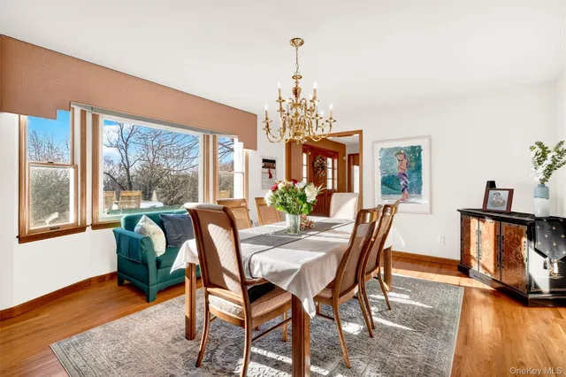 a dining room with furniture a chandelier and wooden floor