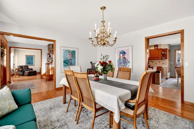 a dining room with furniture a rug a painting and a chandelier