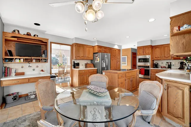 a living room with furniture a flat screen tv and kitchen view
