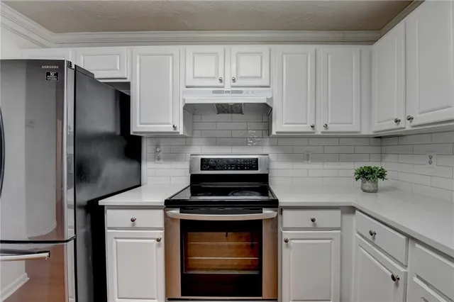 a white kitchen with sink and cabinets