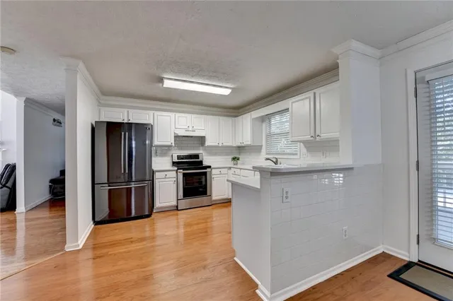 a kitchen with stainless steel appliances a refrigerator and a stove top oven