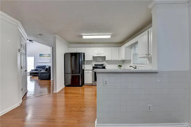 a view of an empty room with window and chandelier fan