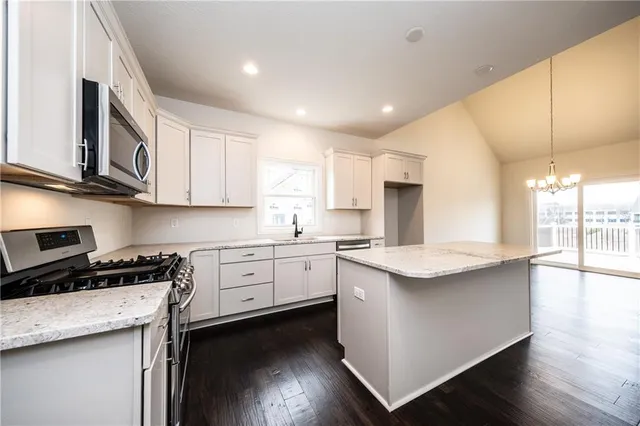 a kitchen with stainless steel appliances granite countertop a sink stove and cabinets