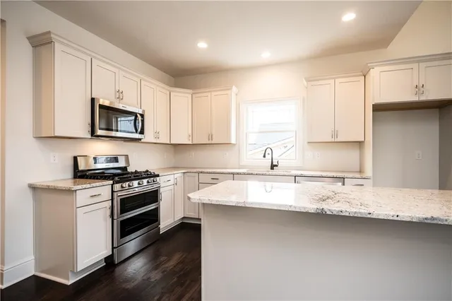 a kitchen with a sink stove top oven and cabinets