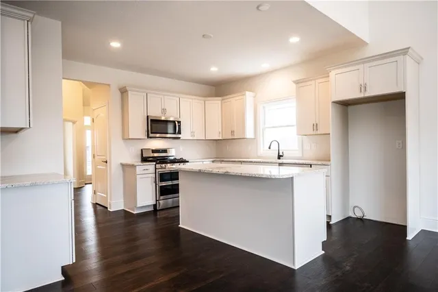 a kitchen with a refrigerator and a stove top oven