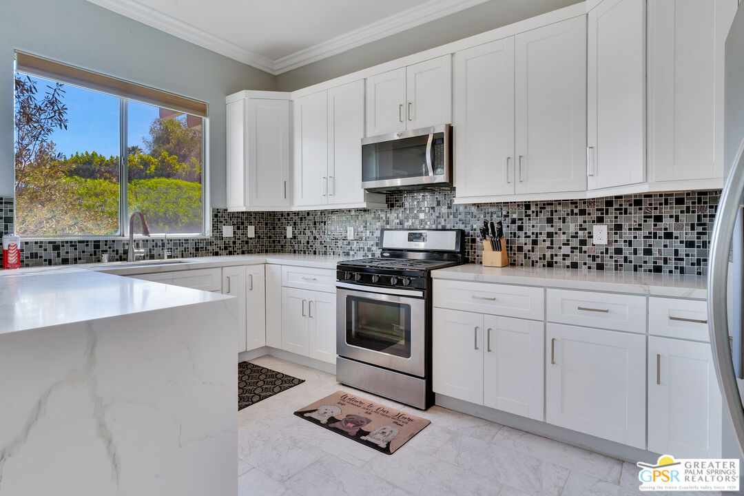 68315 Riviera Road Cathedral City, CA 92234 - Photo 15 of 33 a kitchen with granite countertop white cabinets and white appliances