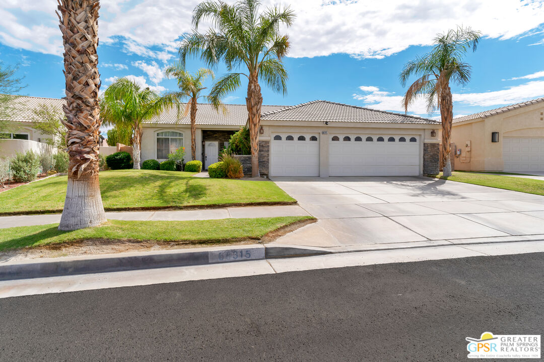 68315 Riviera Road Cathedral City, CA 92234 - Photo 2 of 33 a front view of a house with a yard and garage