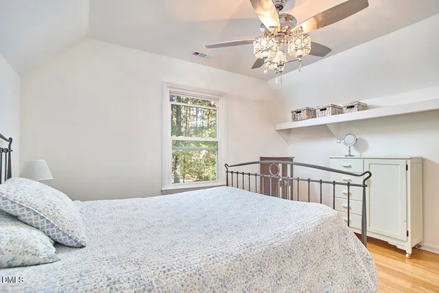 a bedroom with a large bed and a chandelier