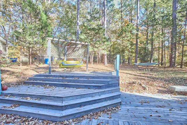 a view of a patio with table and chairs and couches with wooden floor and fence