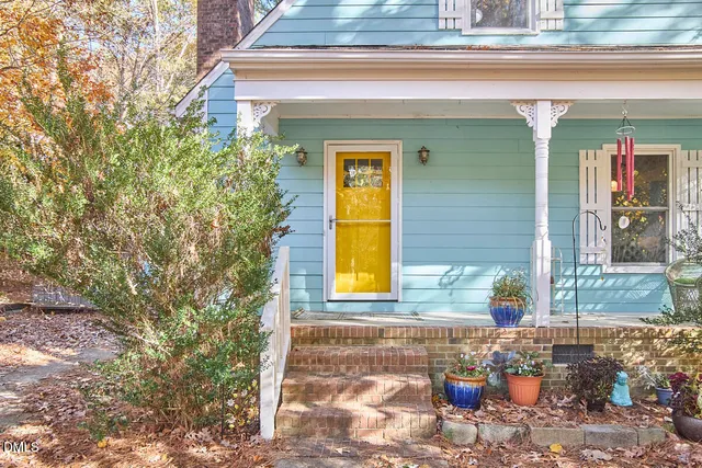 a view of a white house with a yard and sitting area