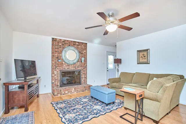 a living room with furniture kitchen view and a wooden floor