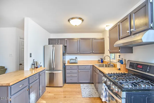 a kitchen with stainless steel appliances granite countertop a sink stove and refrigerator