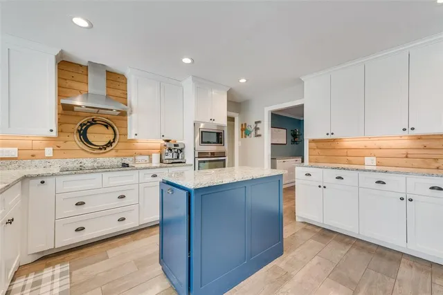 a kitchen with granite countertop a sink stove cabinets and wooden floor