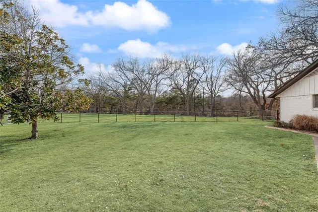a view of a garden with lawn chairs and a fire pit