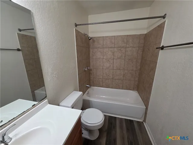 a white toilet sitting next to a bath tub