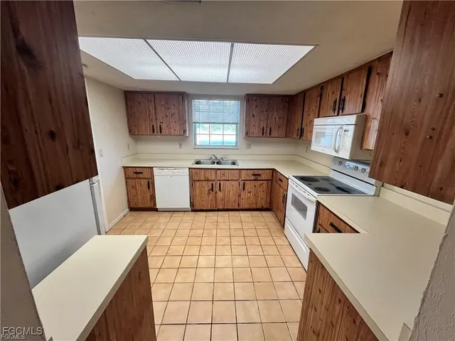a kitchen with a sink a stove top oven a refrigerator and dishwasher