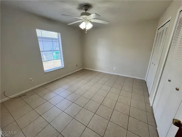 an empty room with windows and fan