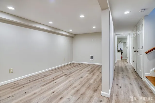an empty room with wooden floor and a bathroom