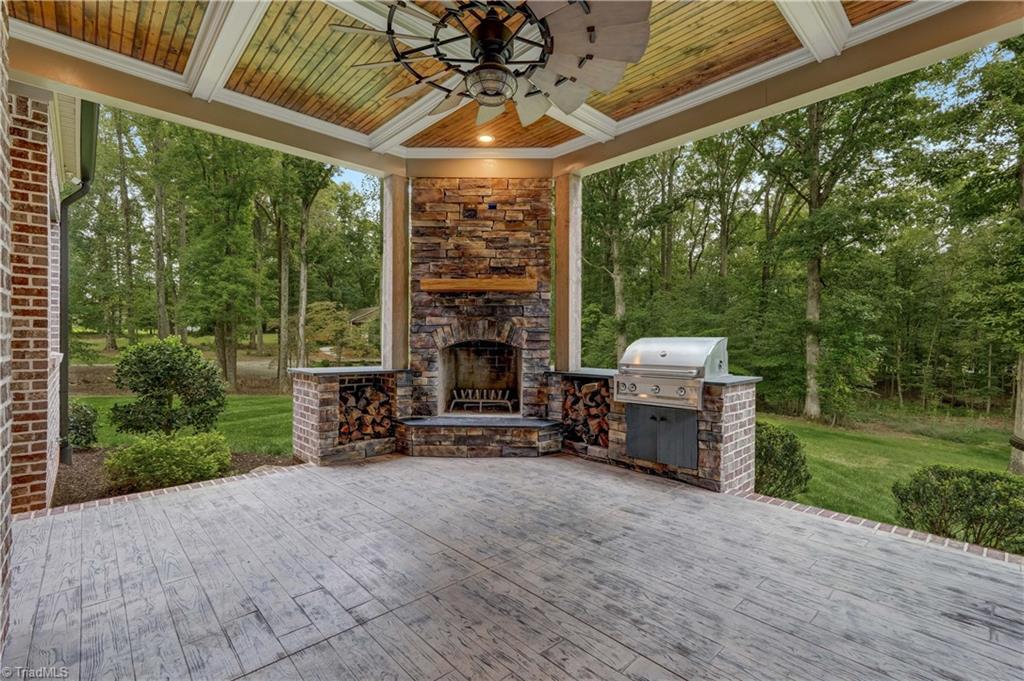 2733 Pleasant Ridge Road Summerfield, NC 27358 - Photo 19 of 41 Covered rear porch with wood burning fireplace & gas grill