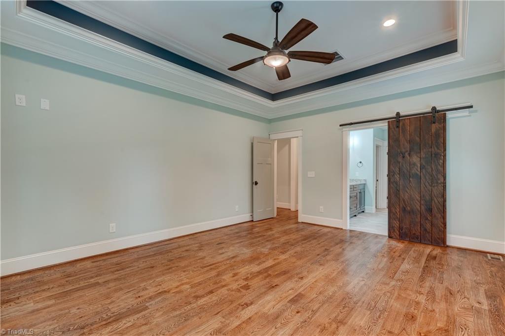 2733 Pleasant Ridge Road Summerfield, NC 27358 - Photo 23 of 41 Primary bedroom with barn door to bath