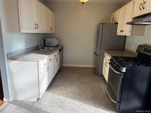 a kitchen with stainless steel appliances granite countertop a stove a refrigerator and a cabinets