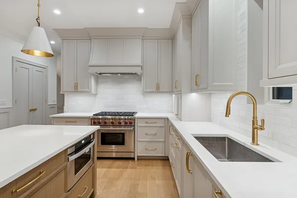 a kitchen with a stove sink and cabinets