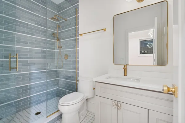 a bathroom with a sink a toilet and shower