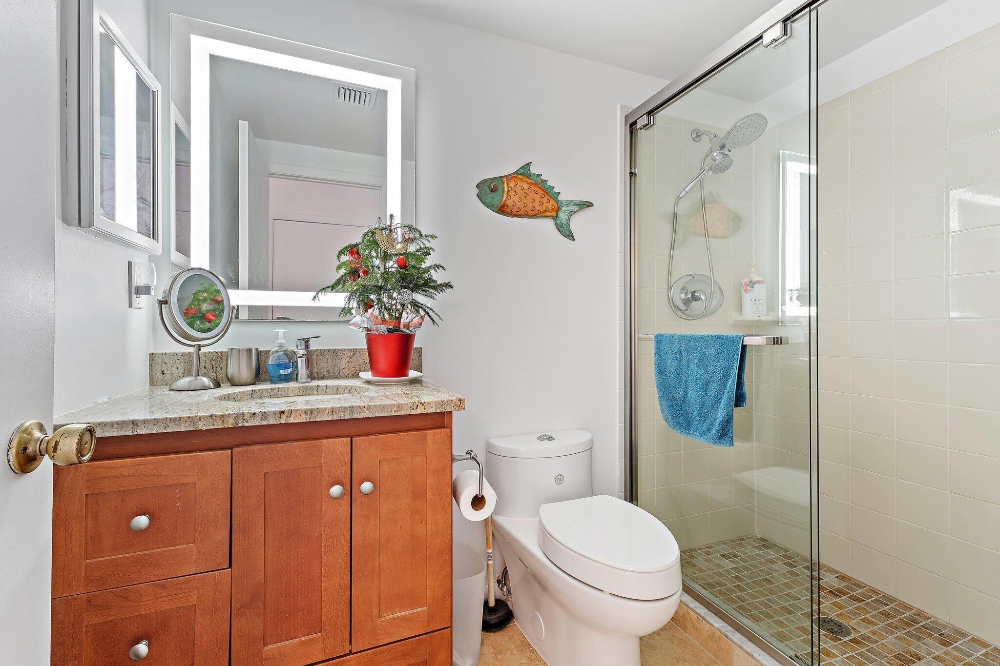 353 Highway 1, Unit C7 Jupiter, FL 33477 - Photo 24 of 45 a bathroom with a granite countertop sink a toilet and shower