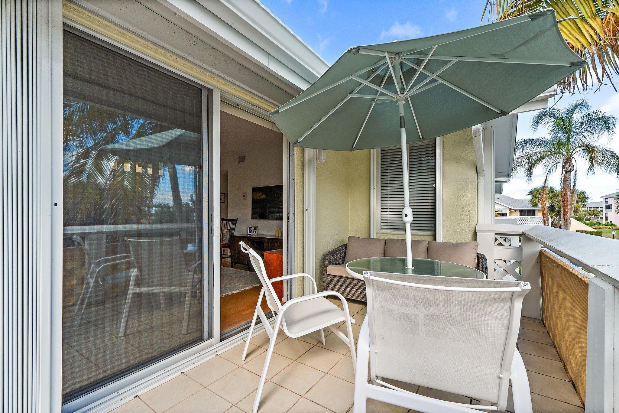 353 Highway 1, Unit C7 Jupiter, FL 33477 - Photo 27 of 45 a patio with a table and chairs under an umbrella