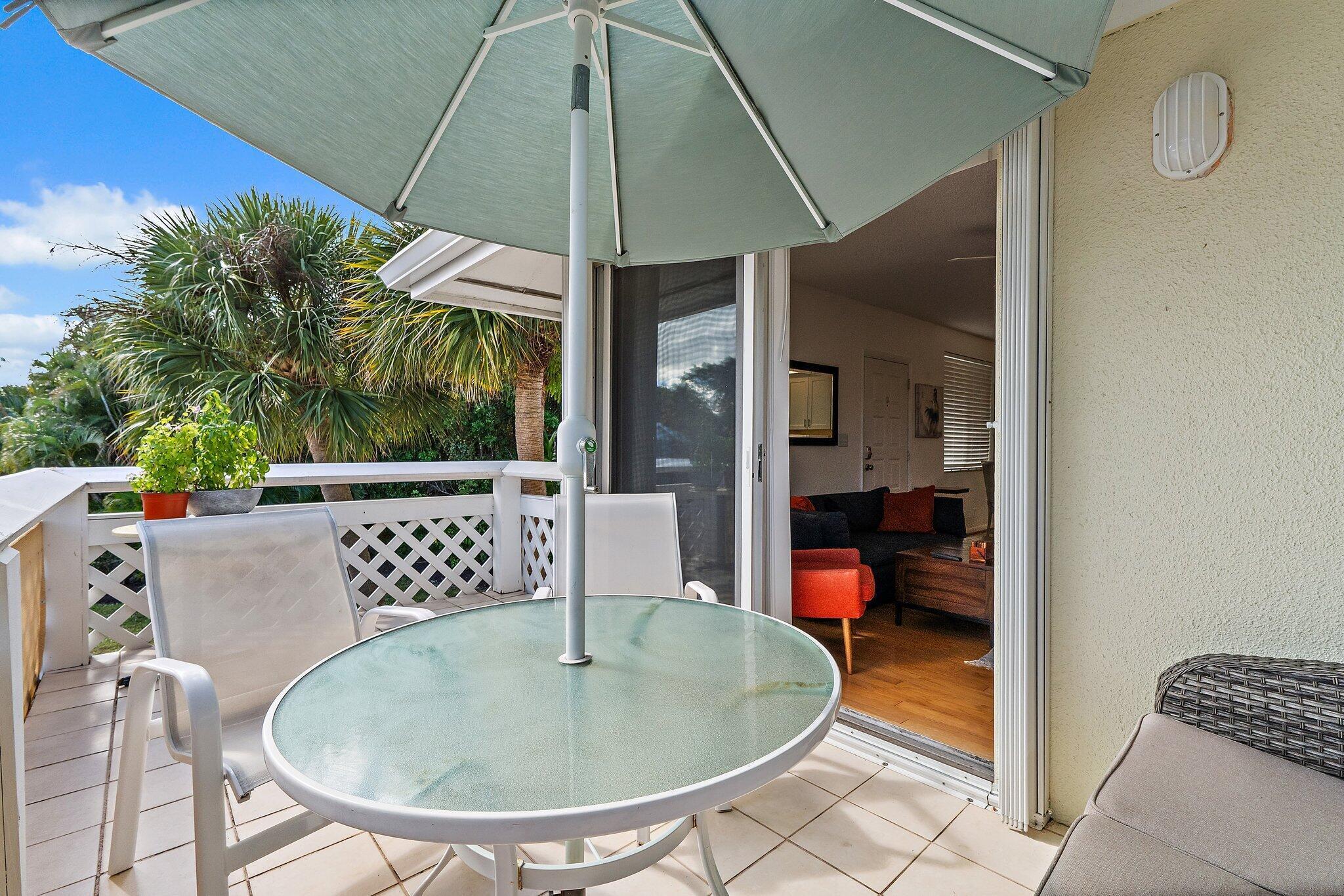 353 Highway 1, Unit C7 Jupiter, FL 33477 - Photo 29 of 45 a dining room with furniture and a umbrella