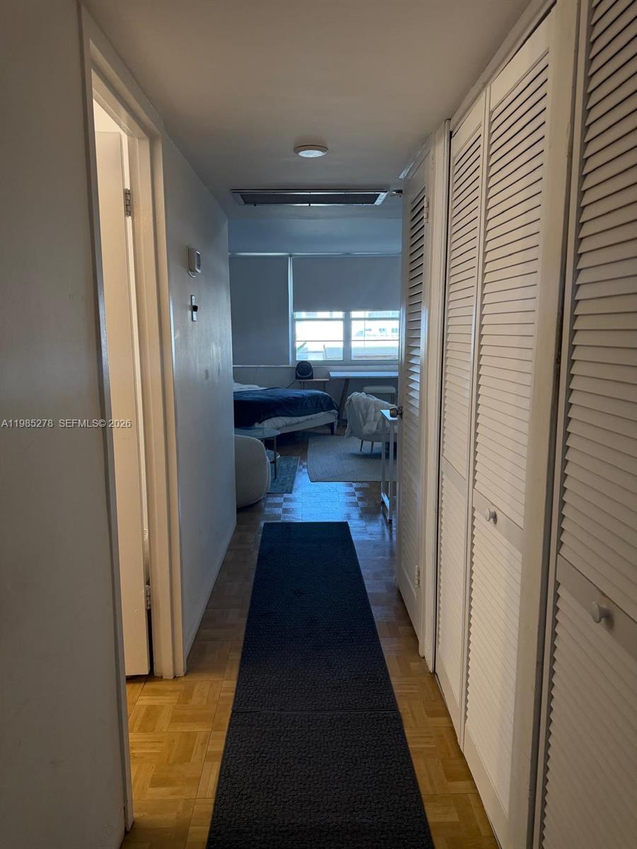 100 Lincoln Road, Unit 1512 Miami Beach, FL 33139 - Photo 5 of 21 a view of a hallway with wooden floor and a bathroom