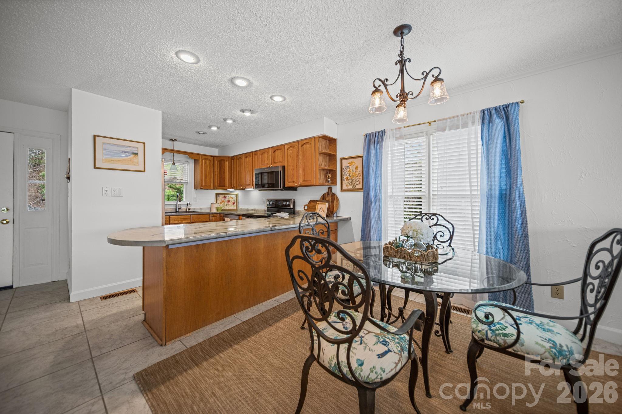 529 Catspaw Road Statesville, NC 28677 - Photo 11 of 48 a kitchen with stainless steel appliances granite countertop a table chairs sink and cabinets