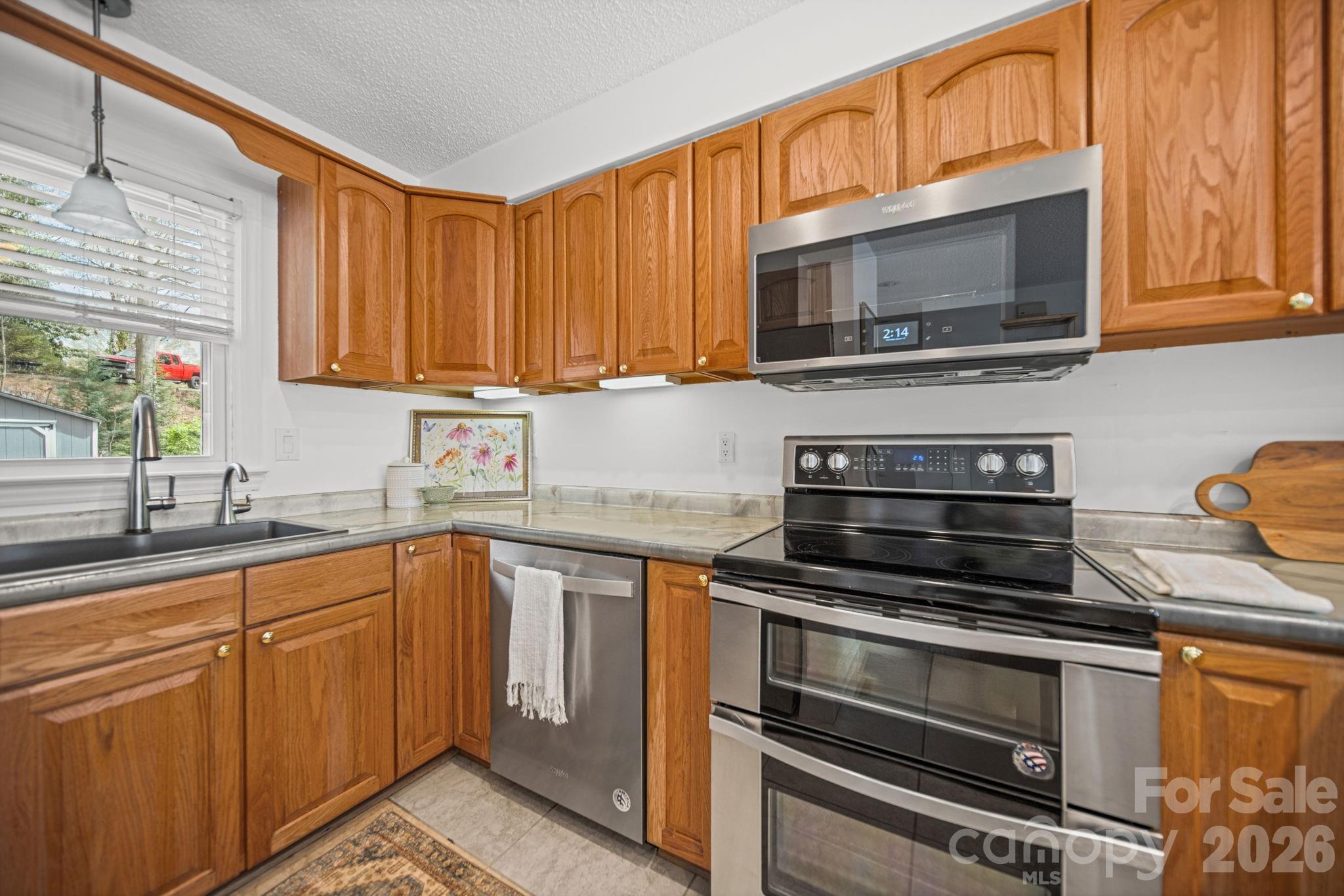 529 Catspaw Road Statesville, NC 28677 - Photo 13 of 48 a kitchen with stainless steel appliances granite countertop a stove microwave and sink with granite countertops