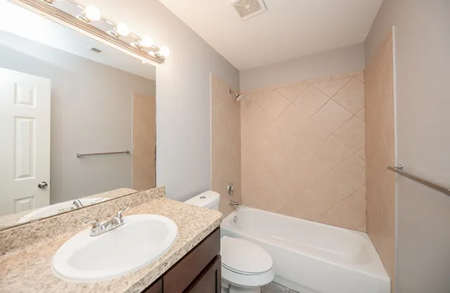 a bathroom with a bathtub shower sink and a toilet