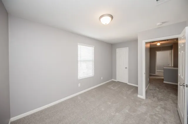 an empty room with windows and a sink
