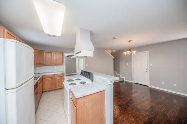 a open kitchen with a sink dishwasher and a refrigerator with wooden floor