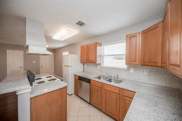 a kitchen with stainless steel appliances granite countertop a sink and a stove