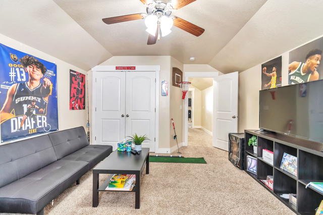 13038 Tower Ridge Drive Riverton, UT 84096 - Photo 26 of 30 Carpeted room featuring a ceiling fan with light fixture, vaulted ceilings, and white double doors