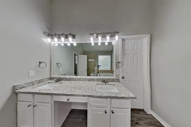 a bathroom with a granite countertop sink a large mirror and a vanity