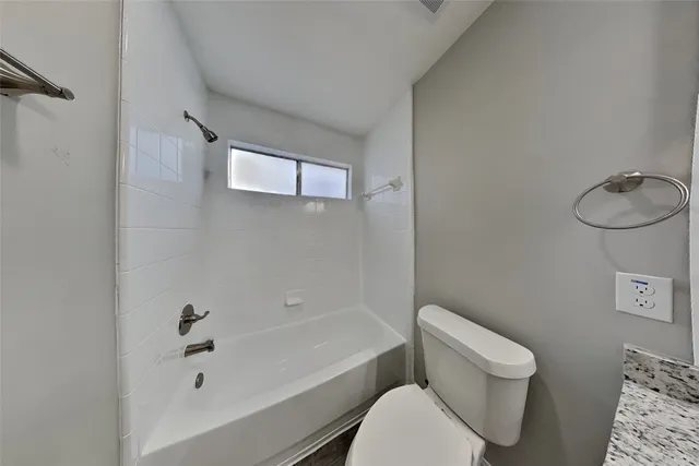 a bathroom with a granite countertop sink a large mirror and a shower
