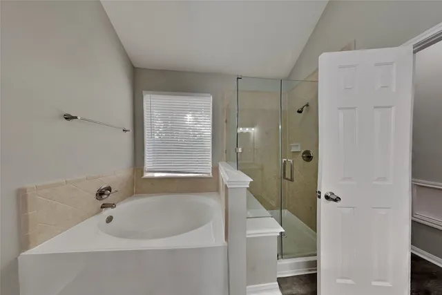 a bathroom with a tub a sink and mirror