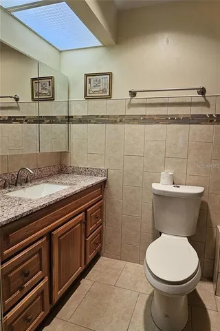 a bathroom with a granite countertop toilet sink and mirror