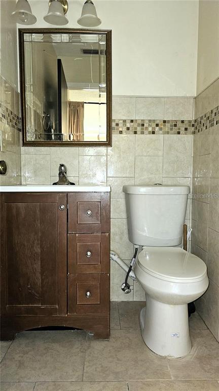 4330 Tahitian Gardens Circle, Unit C Holiday, FL 34691 - Photo 15 of 20 a bathroom with a toilet a sink and mirror